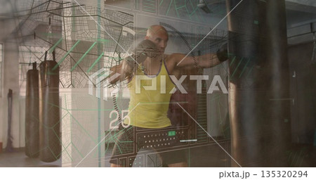 Boxer punching heavy bag in boxing gym, with yellow tank top, black gloves and data overlay 135320294