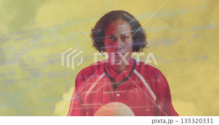 Holding female athlete wearing red jersey with white volleyball against yellow tech studio backdrop 135320331