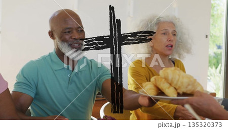 Sharing pastries, senior man wearing green polo shirt at home dining table with plate of croissants 135320373