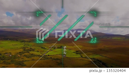 Displaying green heads-up display overlay with corner markers over rural valley with numeric data 135320404