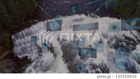 Displaying aerial waterfall cascading into frothy river by evergreens, with holographic data panels Displaying aerial waterfall cascading into frothy river by evergreens, with holographic data panels 135320410