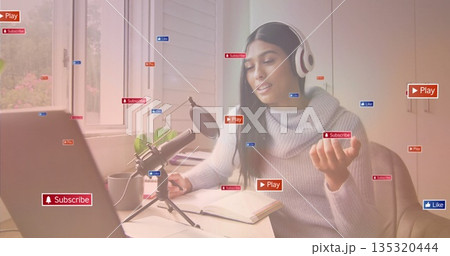 Recording content creator talking at office desk with laptop mic showing Play Subscribe Like icons 135320444