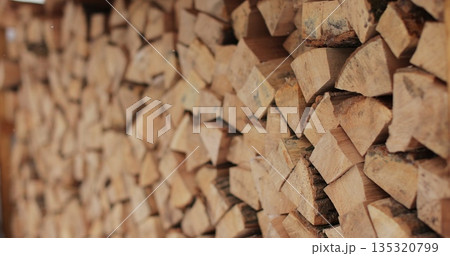 Close-up of a large pile of chopped dry wood for a fireplace or stove. Logs for the fire. Harvesting dry firewood for the winter. Close-up of a large pile of chopped dry wood for a fireplace or stove. Logs for the fire. Harvesting dry firewood for the winter. 135320799