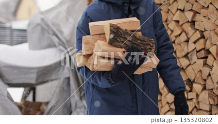 Man takes logs from a woodcutter in his hands for heating in the house. Man takes logs from a woodcutter in his hands for heating in the house. 135320802