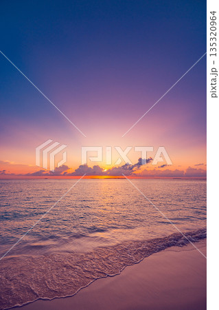Vertical panoramic sunset beach close up ocean waves sand colorful sky summer background 135320964