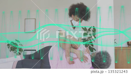 Stretching physiotherapist wearing mask assisting patient on home therapy table with green waveform Stretching physiotherapist wearing mask assisting patient on home therapy table with green waveform 135321243