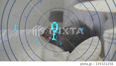 Holding smartphone senior woman reclining on bed in master bedroom, with digital interface overlay 135321258