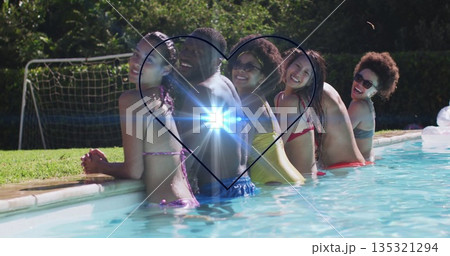 Friends in swimsuits leaning at backyard pool, holding smartphone with heart lens flare effect Friends in swimsuits leaning at backyard pool, holding smartphone with heart lens flare effect 135321294