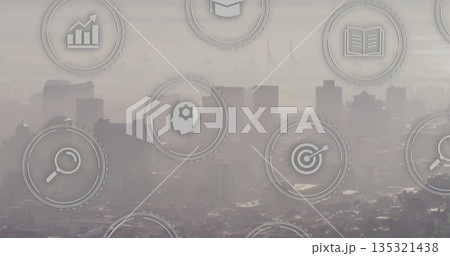 Overlaying icons including magnifying glass and graduation cap over hazy city skyline Overlaying icons including magnifying glass and graduation cap over hazy city skyline 135321438