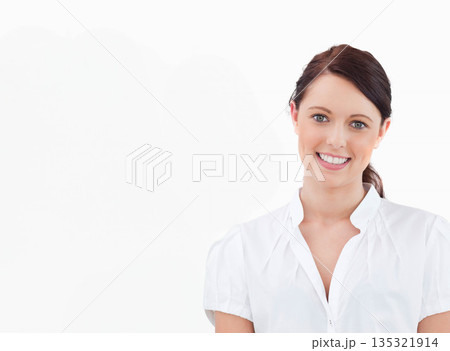 Female smiling while posing in studio against white backdrop with high-key lighting, copy space 135321914
