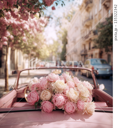 Bouquet of flowers on a vintage convertible in a street lined with cherry blossom trees during the day 135322342