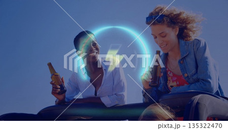 Laughing two women in denim jacket holding beer bottles leaning on convertible seat, sunglasses Laughing two women in denim jacket holding beer bottles leaning on convertible seat, sunglasses 135322470
