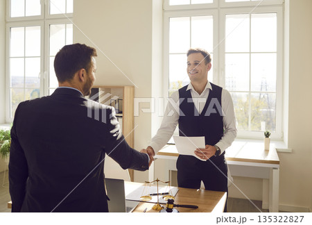 Smiling lawyer and his client shake hands after successful legal consultation. 135322827