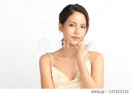 A beautiful young Asian woman with clean, fresh skin against a white background. Skincare, facial treatment, cosmetology, beauty, and spa. An elegant portrait of an Asian woman. 135323132
