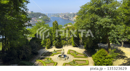 Panoramic summer view of decorative garden with Arrabida bridge and Douro river in Porto, Portugal. Panoramic summer view of decorative garden with Arrabida bridge and Douro river in Porto, Portugal. 135323629