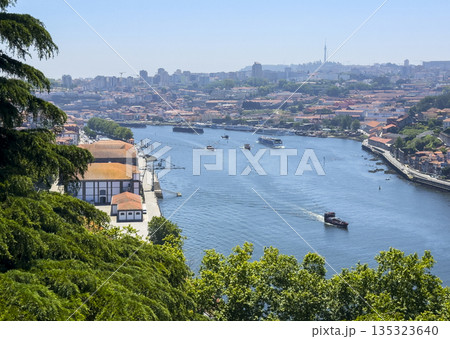 Scenic view of Porto city and Douro river with boats and red rooftops. Summer landscape showing Scenic view of Porto city and Douro river with boats and red rooftops. Summer landscape showing 135323640