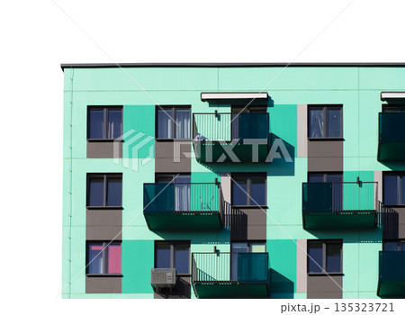 Contemporary apartment building with a turquoise and gray facade, glass balconies, and dark framed 135323721