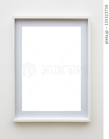 Minimalist white rectangular photo or poster frame with a mat board inside, mounted on a white wall. 135323738