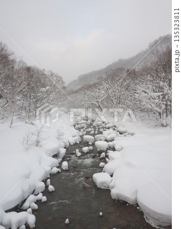 豪雪地帯の静かな川　余白のある厳冬の雪景色 135323811