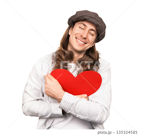 Happy man with long hair and cap hugging a red heart with eyes closed. Smiling romantic guy embracing love symbol isolated on white background. Valentine's Day concept. High quality photo Happy man with long hair and cap hugging a red heart with eyes closed. Smiling romantic guy embracing love symbol isolated on white background. Valentine's Day concept. High quality photo 135324585
