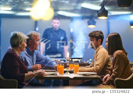 Professional Restaurant Chef Cooking Meat with Flambe Technique at Table for Guests 135324822