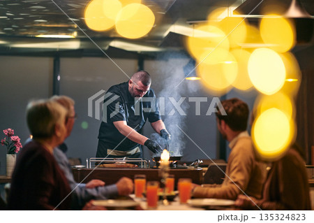 Professional Restaurant Chef Cooking Meat with Flambe Technique at Table for Guests Professional Restaurant Chef Cooking Meat with Flambe Technique at Table for Guests 135324823