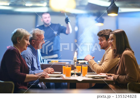 Professional Restaurant Chef Cooking Meat with Flambe Technique at Table for Guests 135324828