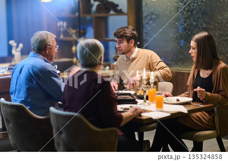 Family enjoying iftar together in a restaurant during Ramadan with traditional decorations 135324858