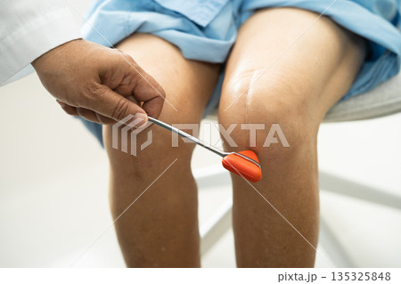 Asian doctor physiotherapist examining, massaging and treatment knee and leg of senior patient in orthopedist medical clinic nurse hospital. 135325848