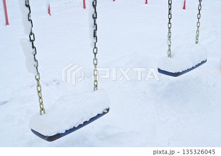 雪が積もった公園にあるブランコ 135326045