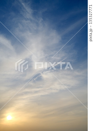 夕空に広がる光と雲のグラデーション　柔らかな色合いの空模様 135327771