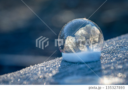 Frozen bubble in nature. A beautiful macro shot of nature in winter. Concept for environment, water and frost. 135327893