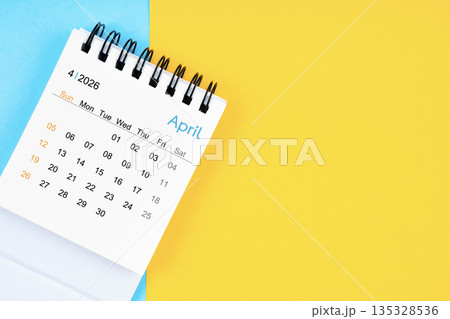 April 2026, Monthly desk calendar for 2026 year on yellow and blue background. 135328536