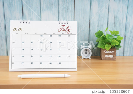 July Monthly desk calendar for 2026 year and alarm clock. 135328607