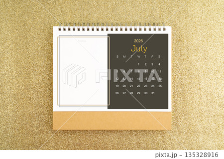 Desk calendar for July 2026 on gold color glitter. 135328916