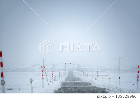 吹雪の雪道と視線誘導標 135328966