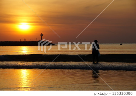 The fisherman and the sea.A fisherman nets fish at dawn. The sea is tinted golden by the sun rising over the horizon. The fisherman and the sea.A fisherman nets fish at dawn. The sea is tinted golden by the sun rising over the horizon. 135330390