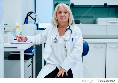 Medical professional in a clinic setting, focused on patient care and health management during a busy workday 135330492