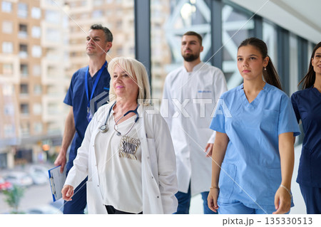 Medical professionals walking through a modern healthcare facility in the city during daytime Medical professionals walking through a modern healthcare facility in the city during daytime 135330513