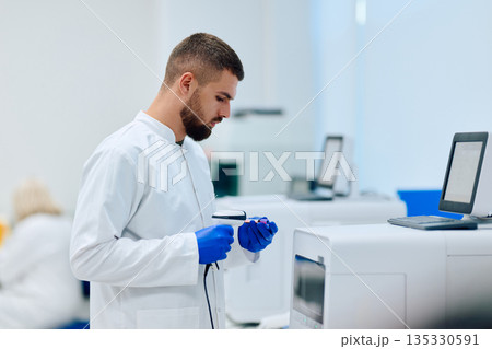 Laboratory technician conducts analysis in modern research facility during daylight hours Laboratory technician conducts analysis in modern research facility during daylight hours 135330591