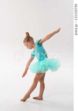 A young dancer with a cochlear implant bends forward in a turquoise ballet costume. Adaptive performance, hearing technology, and physical coordination through classical dance and therapy. A young dancer with a cochlear implant bends forward in a turquoise ballet costume. Adaptive performance, hearing technology, and physical coordination through classical dance and therapy. 135330790