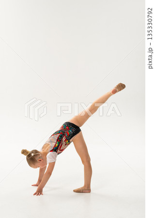 Young gymnast with a cochlear implant performs a forward split balance on the floor. Rehabilitation, auditory technology, and physical development through rhythmic gymnastics and inclusive dance Young gymnast with a cochlear implant performs a forward split balance on the floor. Rehabilitation, auditory technology, and physical development through rhythmic gymnastics and inclusive dance 135330792
