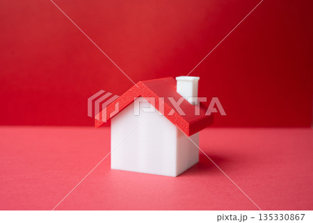 Minimalistic house on a red background. Buying a house. Real estate. Mortgage decisions. Property value. Down payment calculation. Asset growth opportunity. Minimalistic house on a red background. Buying a house. Real estate. Mortgage decisions. Property value. Down payment calculation. Asset growth opportunity. 135330867