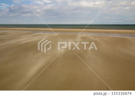 A gust of wind blowing over the beach A gust of wind blowing over the beach 135330874