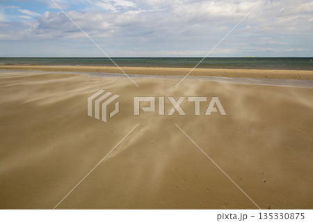 A gust of wind blowing over the beach A gust of wind blowing over the beach 135330875
