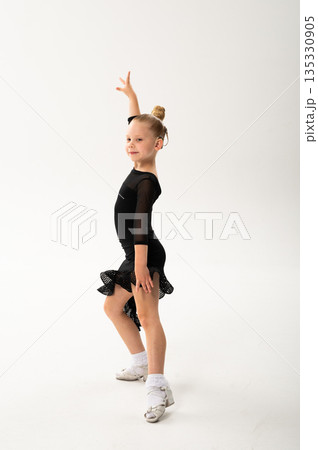 Ballroom dancer with cochlear implant standing in black costume in studio. Pediatric hearing rehabilitation, posture training and inclusive artistic development through body control 135330905