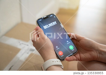 Incoming call about a parcel being delivered by courier to the front door. Last mile logistics, delivery notification and e commerce convenience. Customer experience, home delivery Incoming call about a parcel being delivered by courier to the front door. Last mile logistics, delivery notification and e commerce convenience. Customer experience, home delivery 135330955