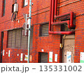 赤レンガの外壁の建物と配管などの都市景観 135331002