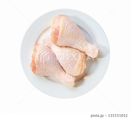 raw chicken legs or chicken drumsticks on a plate isolated on a white background, top view. 135331052