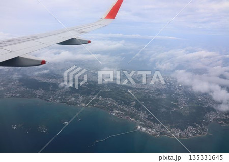 空から見下ろす、海沿いの街と赤い翼 135331645